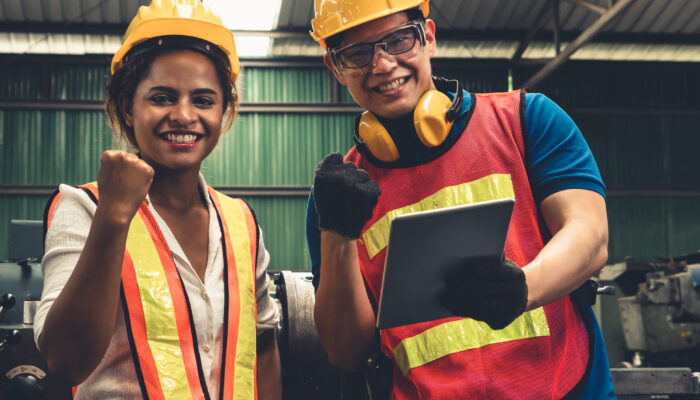 Two skillful factory engineer or worker happy portrait looking at camera